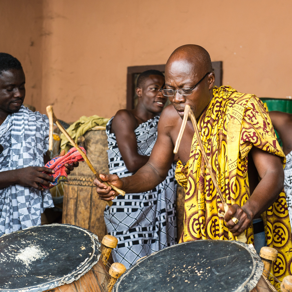 Traditional drummers playing kete drums in matching cloth