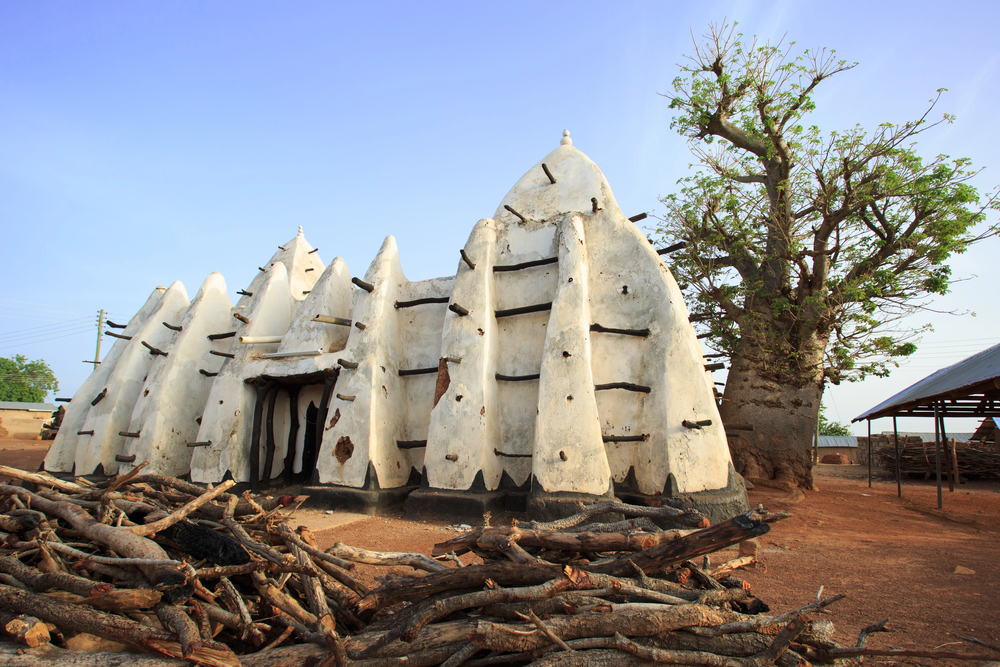 The mud-and-stick Sudanese-style Larabanga Mosque beside a baobab tree